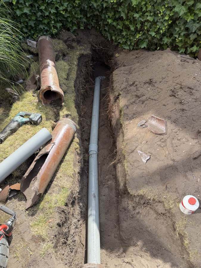 Oude gebroken gresbuis naast de nieuw gelegde pvc-leiding